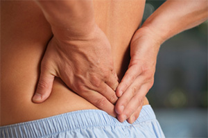 Image of a man holding his lower back in pain